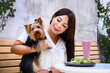 Young woman enjoying brunch with her yorkshire terrier