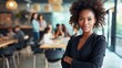 Portrait of young African American female looking camera standing arm crossed in front of colleagues running a business startup or new career path occupation, businesswoman lady lifestyle working