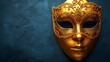  A golden masquerade mask against a blue backdrop, adorned with intricate gold filigree along its side