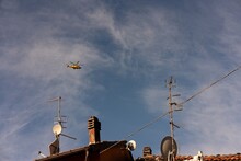 Yellow Rescue Helicopter Flies Over Rooftops In Italy.