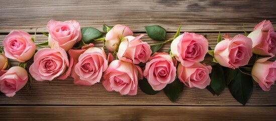 Wall Mural - A lovely display of pink roses delicately placed on a rustic wooden table, surrounded by fresh green leaves for a natural touch