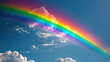Vivid Rainbow in blue Sky with clouds with copy space.