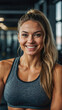 fit blonde young woman in the gym smiling while looking at the camera