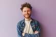 Portrait of a handsome young man with a beard in a denim jacket on a purple background