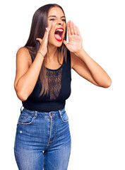 Wall Mural - Young hispanic woman wearing casual clothes shouting angry out loud with hands over mouth