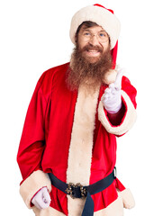 Poster - Handsome young red head man with long beard wearing santa claus costume smiling friendly offering handshake as greeting and welcoming. successful business.