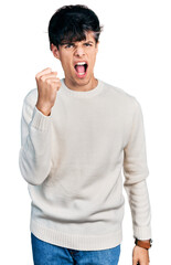 Sticker - Handsome hipster young man wearing casual winter sweater angry and mad raising fist frustrated and furious while shouting with anger. rage and aggressive concept.