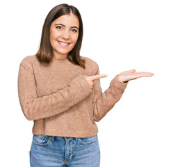 Poster - Young beautiful woman wearing casual clothes amazed and smiling to the camera while presenting with hand and pointing with finger.