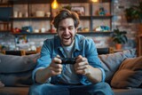 Fototapeta  - Enthusiastic man gaming with a controller on the sofa, displaying a happy demeanor