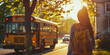 schoolgirl with a backpack behind her back waits for a yellow school bus in the morning