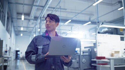 Leinwandbilder - Focused Asian Engineer Walking and Using a Laptop Computer at Electronics Manufacturing Factory. Adult Technician Thinking About Daily Tasks and Working on Research and Development Pipeline