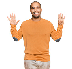 Canvas Print - Hispanic adult man wearing casual winter sweater showing and pointing up with fingers number nine while smiling confident and happy.