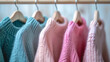 © puhimec - Knitted sweaters on hangers in a clothing store close-up, soft selective focus.