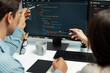 © Summit Art Creations - Team skilled developers program coding discussing creative website planning software project on two screen monitor's full stack data analyzing design at office with back side view concept. Postulate.