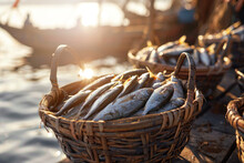 A Woven Basket With Freshly Caught Fish In The Harbor Against The Background Of Boats, Close-up With A Sunset In The Background
