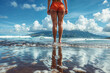 Close-up of woman's legs standing in the ocean water, seen behind