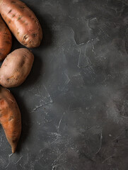 Sticker - Organic sweet potatoes on a textured dark surface.