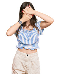 Sticker - Young beautiful caucasian girl wearing casual clothes covering eyes and mouth with hands, surprised and shocked. hiding emotion