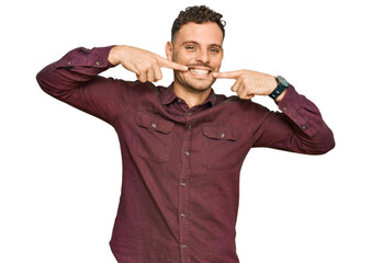 Poster - Young hispanic man wearing casual clothes smiling cheerful showing and pointing with fingers teeth and mouth. dental health concept.