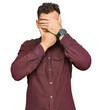 Young hispanic man wearing casual clothes covering eyes and mouth with hands, surprised and shocked. hiding emotion