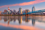 Fototapeta Paryż - Cincinnati, Ohio, USA. Cityscape image of Cincinnati, Ohio, USA downtown skyline with the John A. Roebling Suspension Bridge and reflection of the city in the Ohio River at spring sunrise.