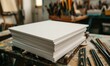A stack of white paper pads surrounded by graphite pencils in an artist's studio