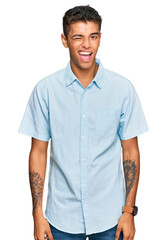 Canvas Print - Young handsome african american man wearing casual clothes winking looking at the camera with sexy expression, cheerful and happy face.