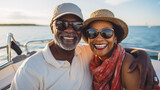 Fototapeta Uliczki - Smiling mature black couple enjoying leisure sailboat ride in summer