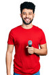 © Krakenimages.com - Young arab man with beard singing song using microphone looking positive and happy standing and smiling with a confident smile showing teeth