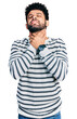 © Krakenimages.com - Young arab man with beard wearing casual striped sweater shouting suffocate because painful strangle. health problem. asphyxiate and suicide concept.