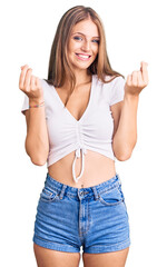 Wall Mural - Young beautiful blonde woman wearing casual white tshirt doing money gesture with hands, asking for salary payment, millionaire business