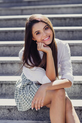 Sticker - Vertical portrait of peaceful lovely girl sitting stairs hand touch cheek spend free time sunny weather outdoors