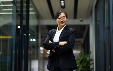 Portrait Smiling confident young business woman standing at home office. looking at camera arms crossed