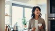 Portrait of stylish asian woman standing in kitchen with mug drinking coffee explaining smth showing