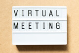 Fototapeta  - Lightbox with word virtual meeting on wood background