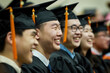 Cheerful Asian graduates in gowns and caps with tassels.