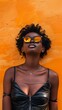 Stylish woman posing against orange wall