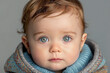 A baby with blue eyes and a blue sweater