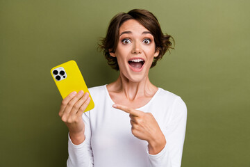 Sticker - Photo portrait of lovely young lady hold point excited device dressed stylish white garment isolated on khaki color background