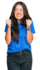 Wall Mural - Beautiful brunette young woman wearing casual clothes excited for success with arms raised and eyes closed celebrating victory smiling. winner concept.