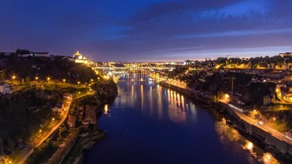 Wall Mural - Day to night transition aerial view of the historic city of Porto, Portugal timelapse panorama with the Dom Luiz bridge. Illuminated waterfront and curved river from above