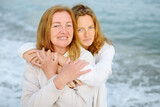 Fototapeta Miasta - Cute woman tenderly hugs her mature mother on Mother's Day