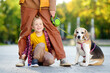 Happy family, mother and little son, walking with dog in park on autumn day. Active playful child playing with mom and domestic pet. Difficulties of upbringing of kids with adhd
