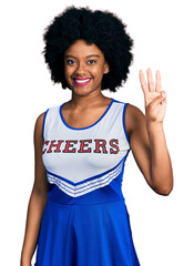 Canvas Print - Young african american woman wearing cheerleader uniform showing and pointing up with fingers number three while smiling confident and happy.