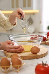 Sticker - Woman whisking eggs in bowl at light marble table indoors, closeup