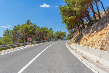 Wall Mural - A white car drives along the sea coastline on a sunny summer day.