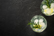 Gin tonic with gin, tonic, ice cubes, lime and rosemary.