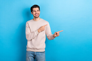 Fototapete - Photo of young nice man look indicate finger empty space wear beige sweatshirt isolated on blue color background