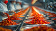 Conveyor belt with red chili peppers in a food factory.