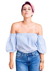 Poster - Young beautiful woman with pink hair wearing casual clothes looking at the camera blowing a kiss on air being lovely and sexy. love expression.